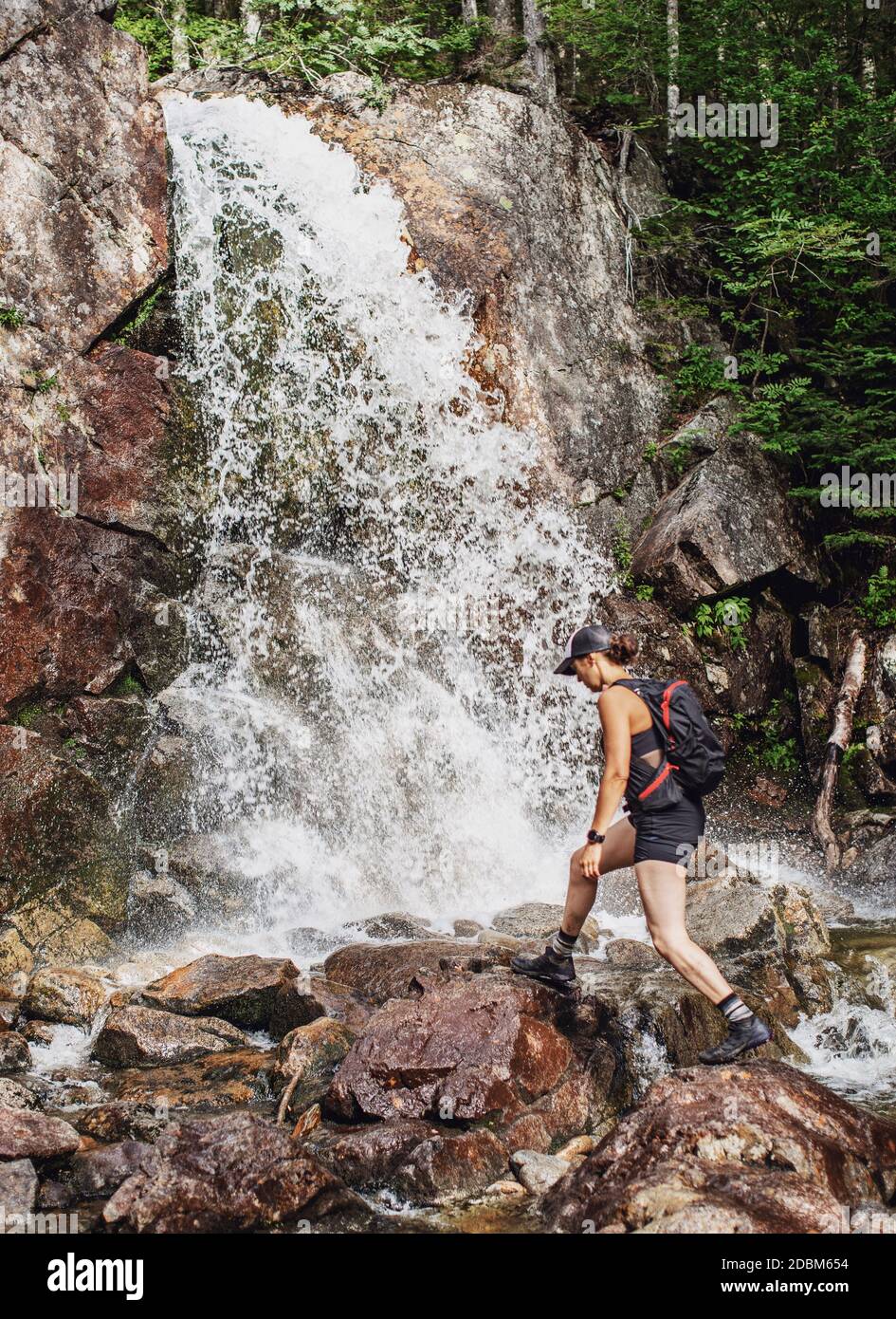 Weibliche Wanderin bei einem Spaziergang in der Nähe von Waterfall, White Mountains, New Hampshire, USA Stockfoto