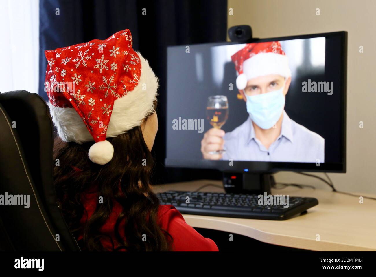 Neujahrsfest in der Ferne während der Coronavirus-Pandemie. Mann und Frau wünschen sich gegenseitig ein frohes Weihnachtsfest per Online-Video-Chat Stockfoto