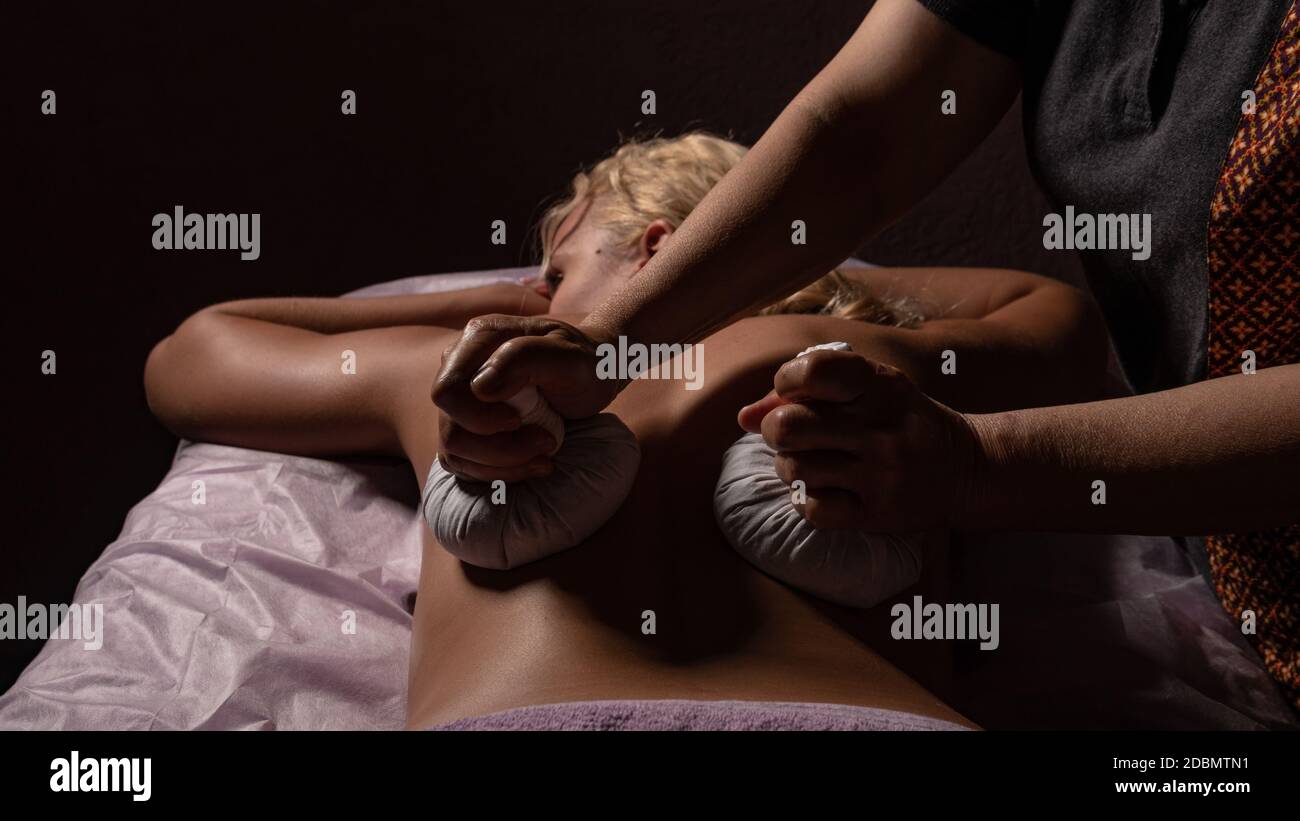 Massage mit Taschen auf schwarzem Hintergrund , liegt das Mädchen in der dunklen, blonden, Gesicht geschlossen Stockfoto