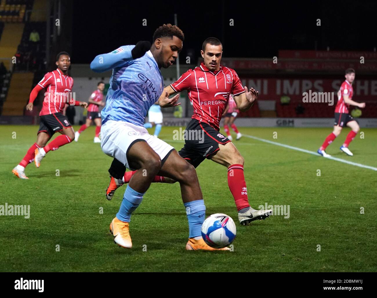 Lincoln City Remy Howarth und Manchester City Jayden Braaf (links) Kampf um den Ball während der Papa John's Trophy Spiel in Sincil Bank, Lincoln. Stockfoto