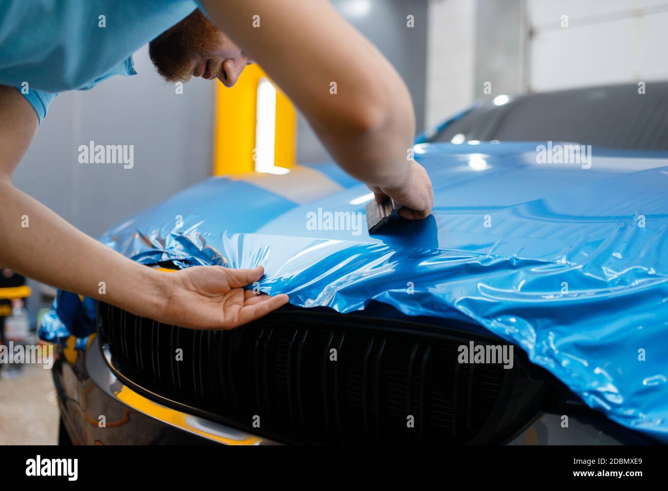 Männliche Auto-Wrapper setzt Schutzfolie oder Folie auf Haube. Arbeiter  macht Auto-Details. Automobil-Lackschutz Beschichtung, professionelles  Tuning Stockfotografie - Alamy