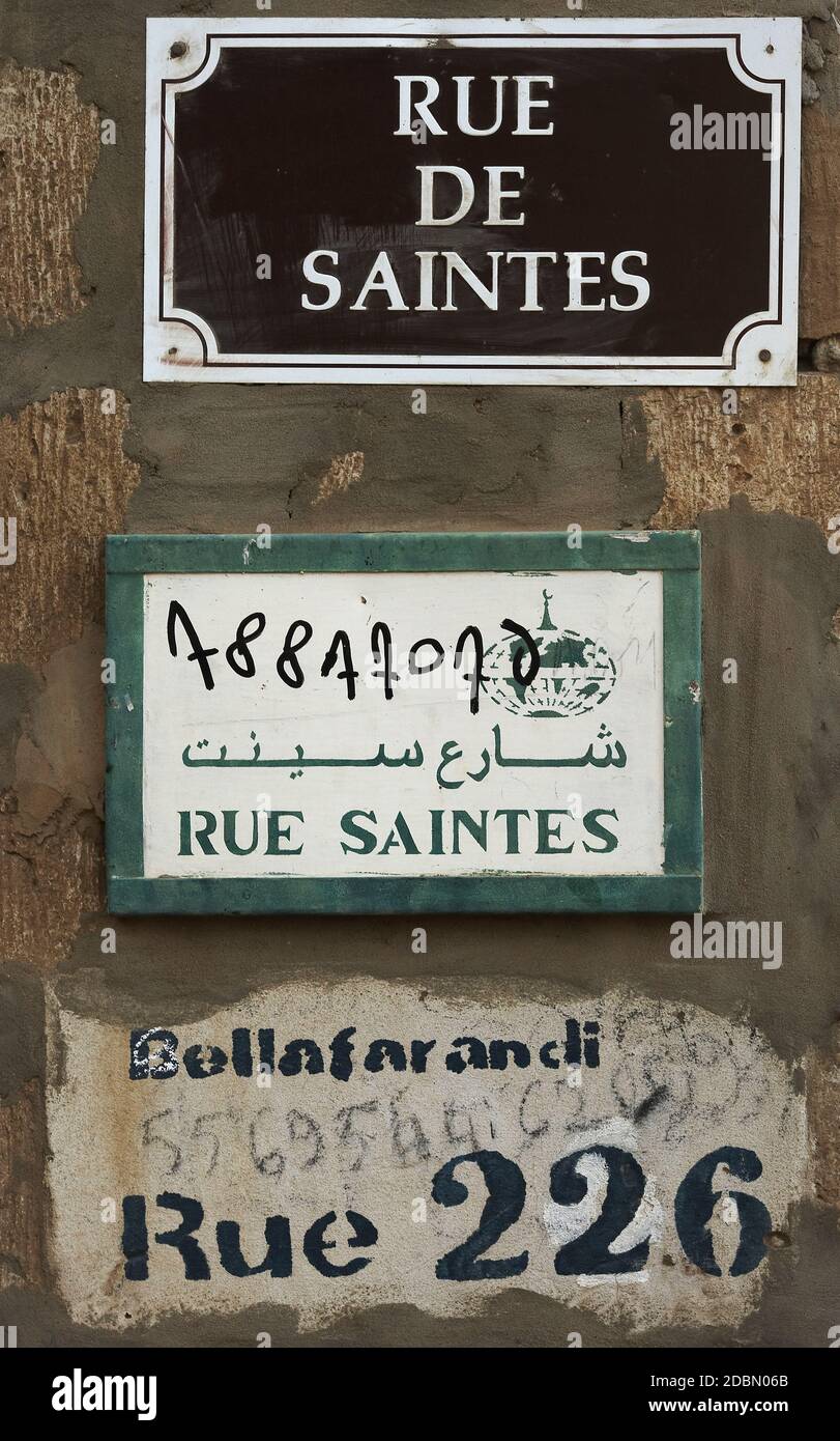 Straßenschilder auf arabisch und Französisch. Mehrere Straßenschilder hängen an der Wand in Timbuktu, Mali, Afrika. Stockfoto