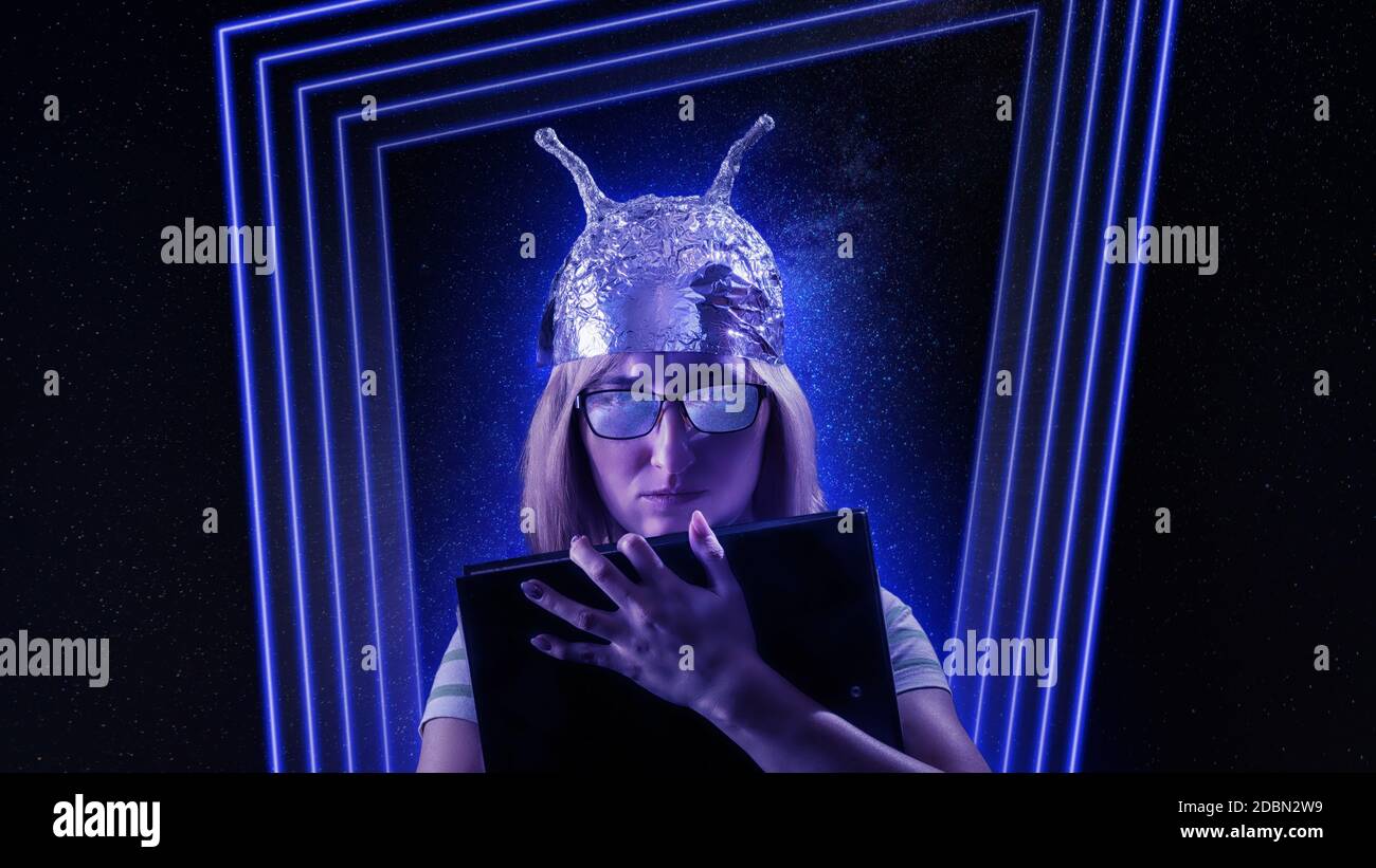 Mädchen in einem Folienhut gegen fantastische Raum Thema Hintergrund. Сonspiracy Theorien, Fantasie und Mystik Themenbild Stockfoto