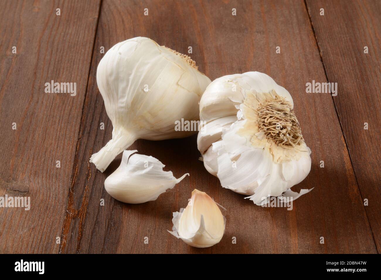 Frische Knoblauchzwiebeln auf einer rustikalen Holztheke Stockfoto