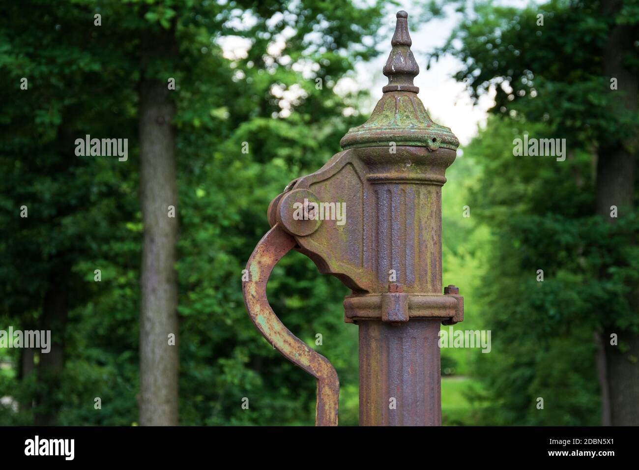 Handwasserpumpe. Alte manuelle Pumpe Brunnen im Park. Foto des alten Stils gut Objekt. Alte antike Metallmechanik. Stockfoto