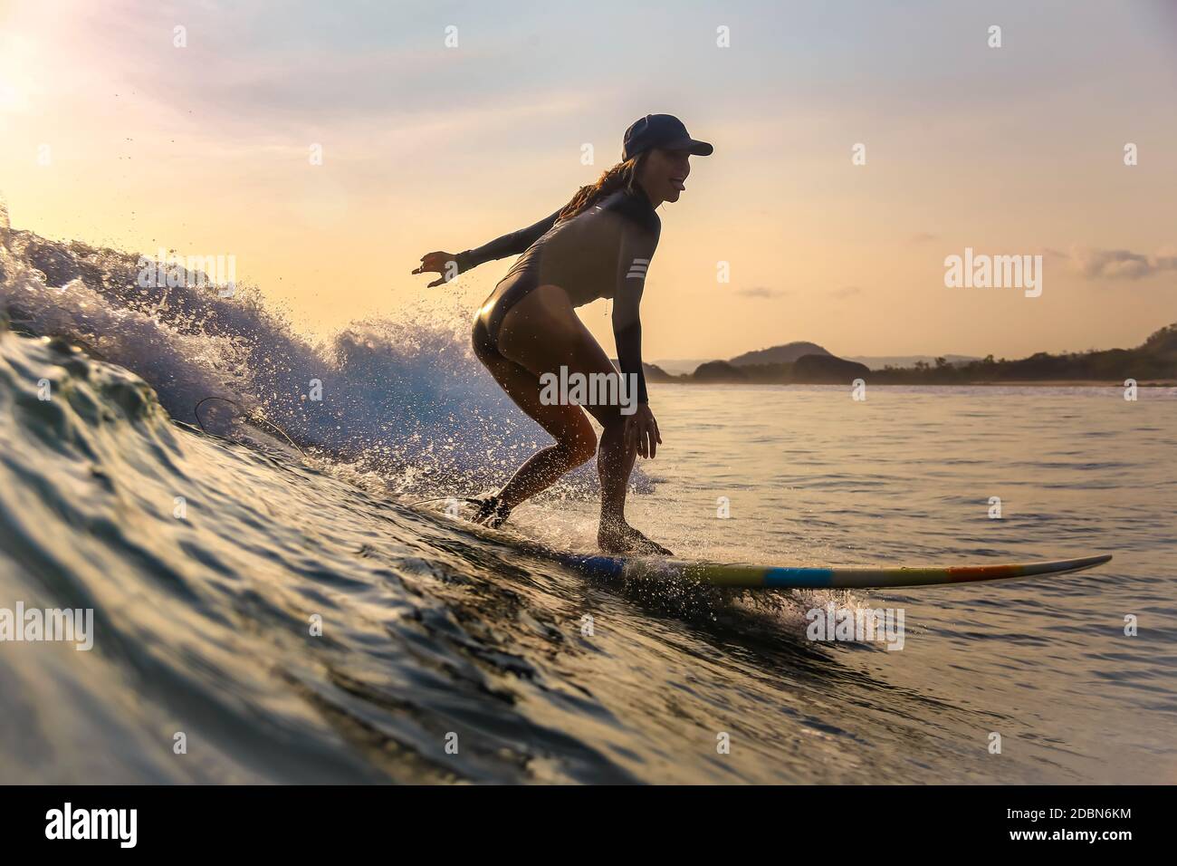 Junge Frau beim Surfen bei Sonnenuntergang, Kuta, Lombok, Indonesien Stockfoto