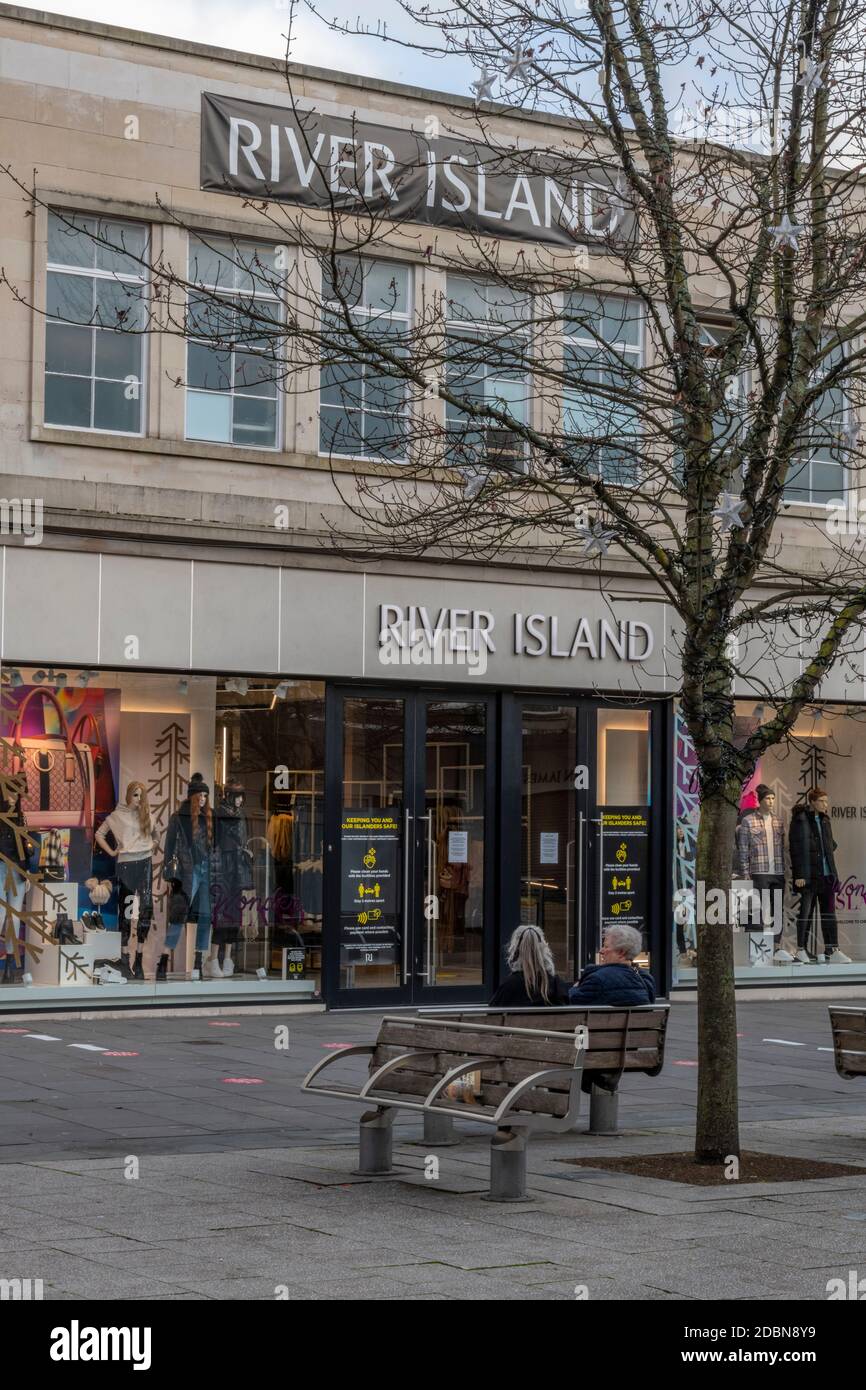 Ein großer Straßenzweig der River Island Bekleidungsgeschichte im Stadtzentrum von southampton mit zwei Frauen, die draußen auf einer Bank sitzen. Stockfoto