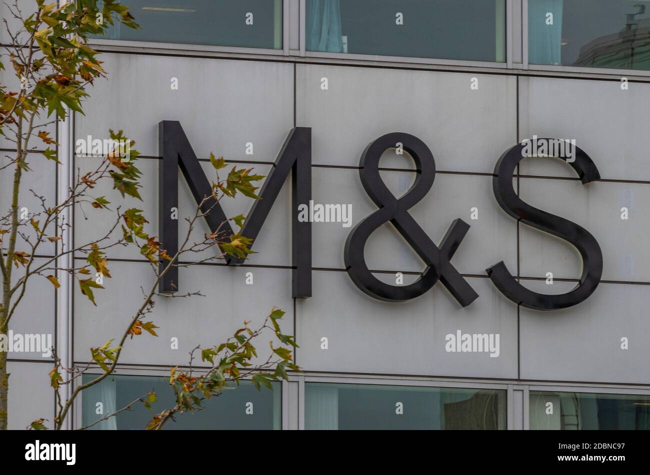 Marks und spencer Ladenschild mit Herbstbäumen neben Markenbanner. Stockfoto