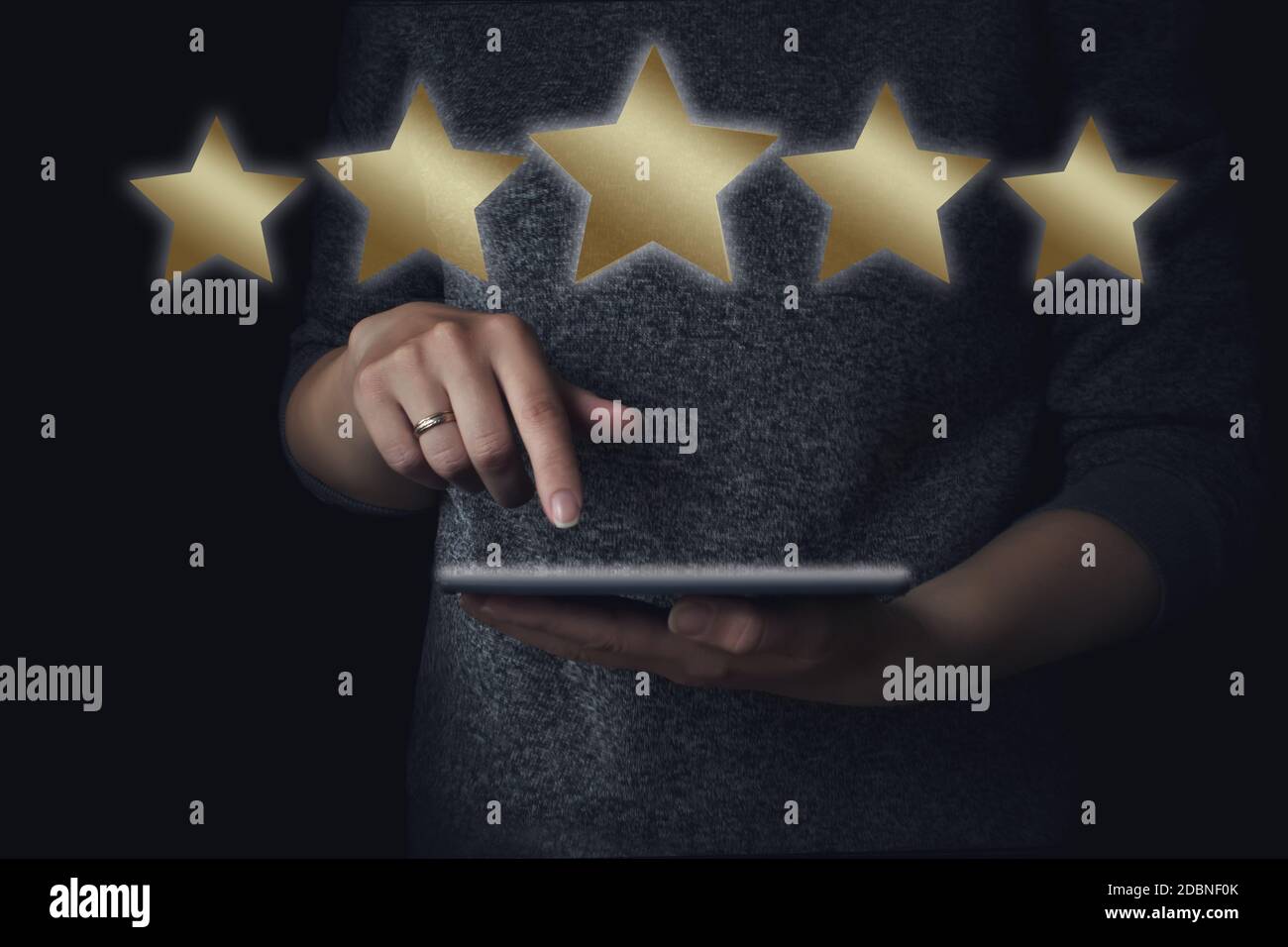Fünf Sterne Service Rating Konzept. Frau mit einem digitalen Tablet in den Händen mit einem 5 goldenen Sternen über einem Bildschirm Stockfoto