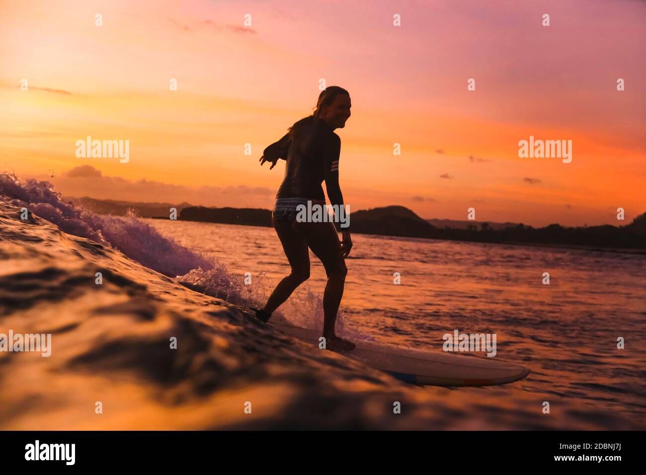 Junge Frau beim Surfen bei Sonnenuntergang, Kuta, Lombok, Indonesien Stockfoto
