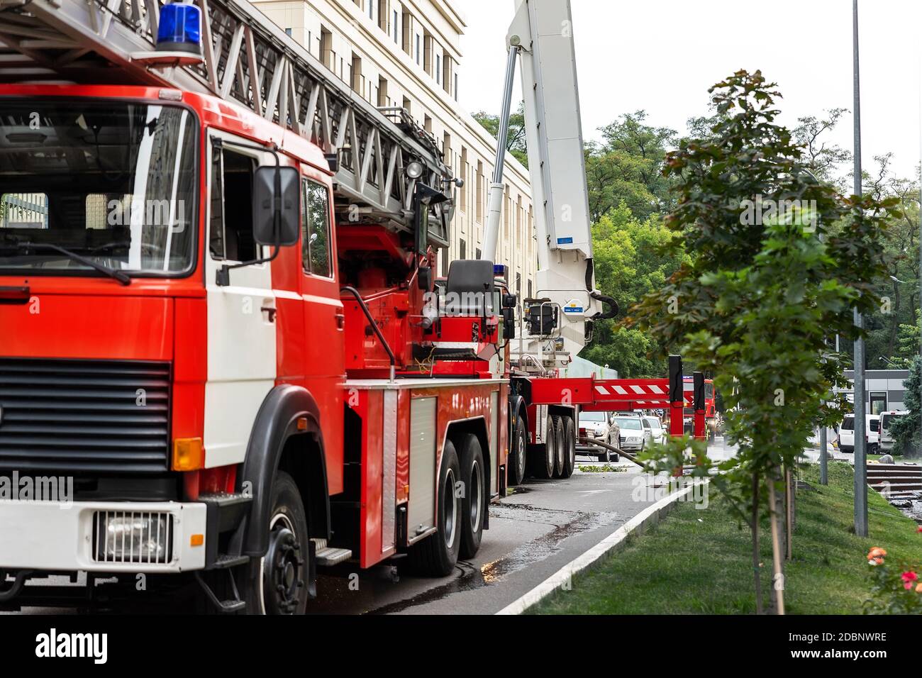 Viele Feuerwehrfahrzeuge mit Leiter und Sicherheitsausrüstung bei Unfall in Hochhaus Turm Wohnwohnung oder Bürogebäude in Stadtzentrum Stockfoto