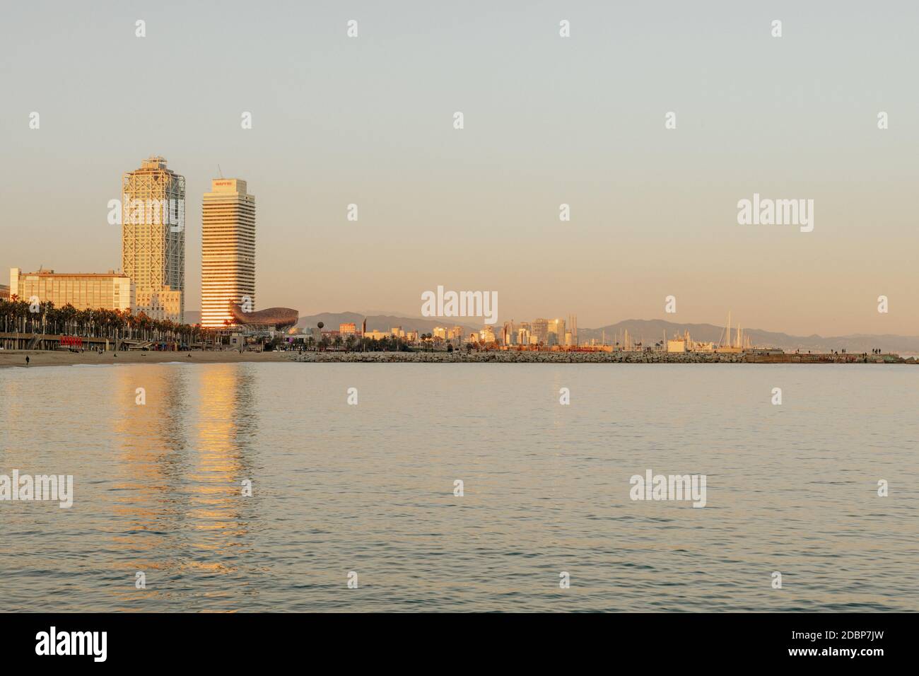 Skyline von Barcelona vom Strand aus, mit Blick auf die Twin Towers von Barcelona Gebäude, reflektiert auf dem Wasser Stockfoto