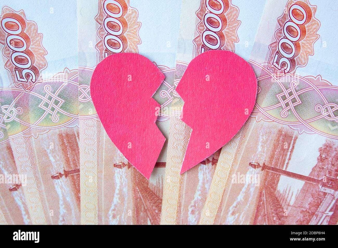 Valentinsherz zerbrochen in zwei auf Rubel Banknoten. Liebe kann nicht erzwungen werden. Die Ehe der Bequemlichkeit. Mehr Geld lieben als Menschen. Stockfoto