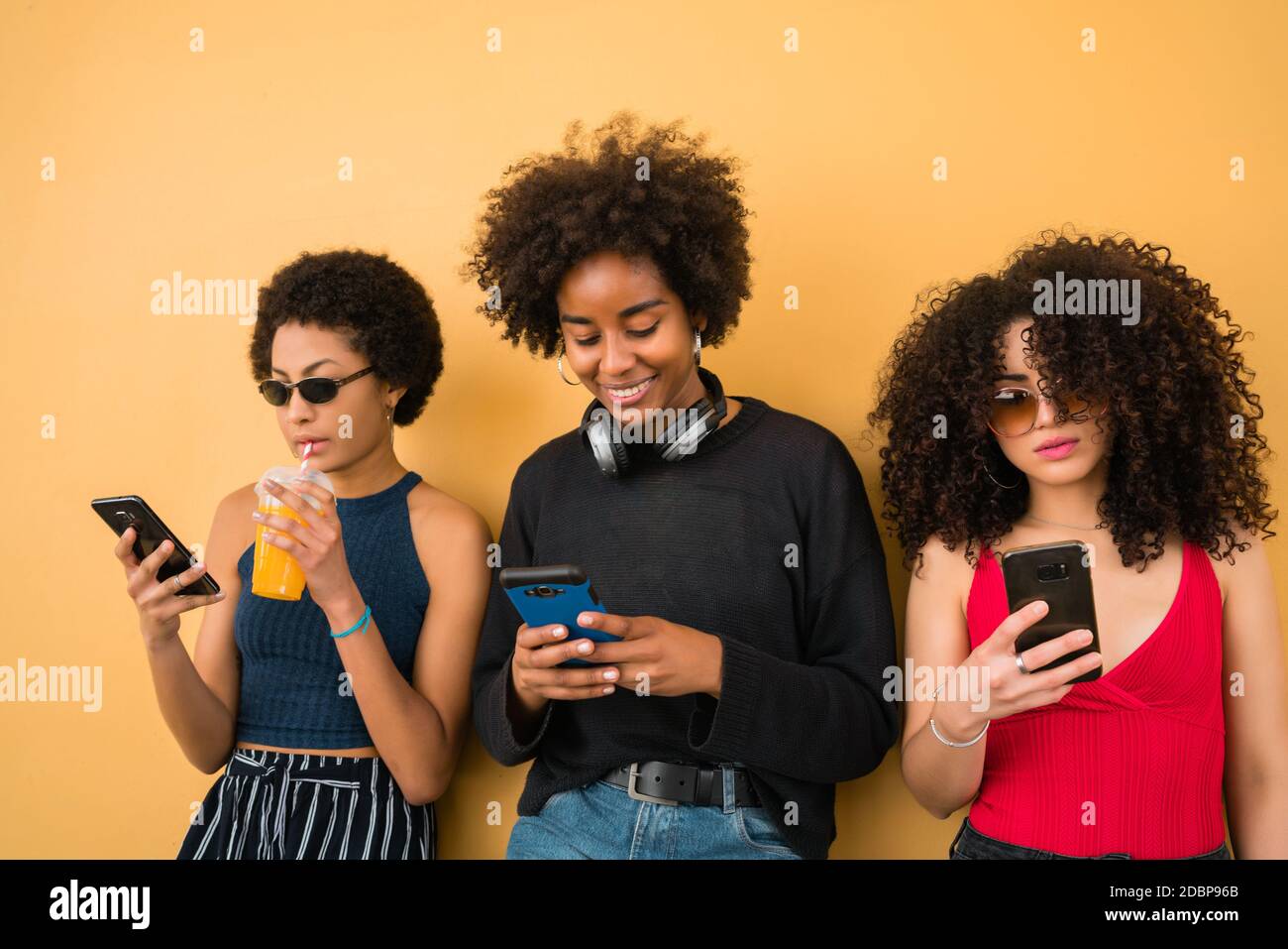 Drei Afro-Freunde mit ihrem Handy. Stockfoto