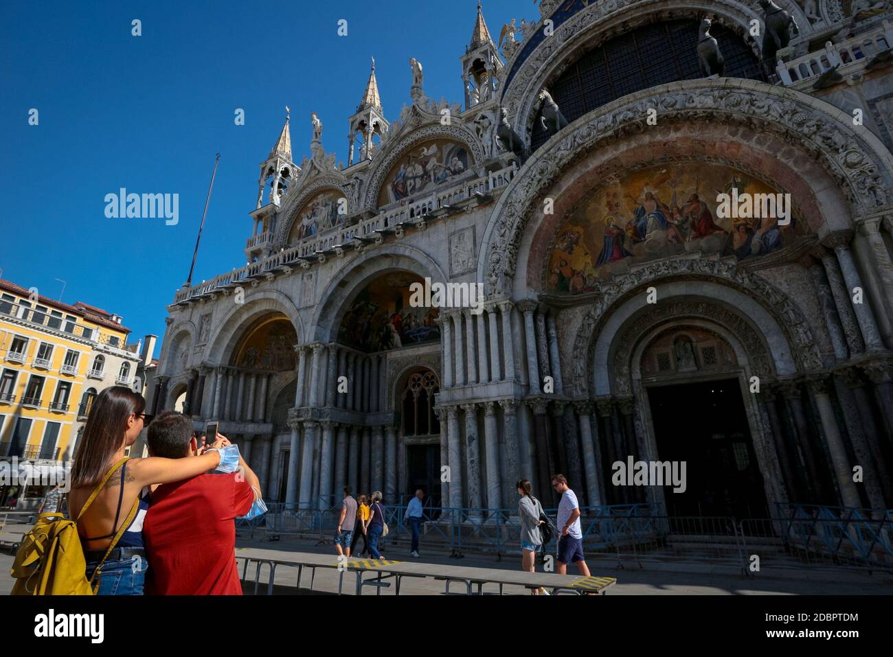 Venedig Tourismus in der Markusbasilika mit Touristen, die während der Coronavirus-Krise in Italien Selfies mit chirurgischen Masken auf ihren Armen machen. Stockfoto