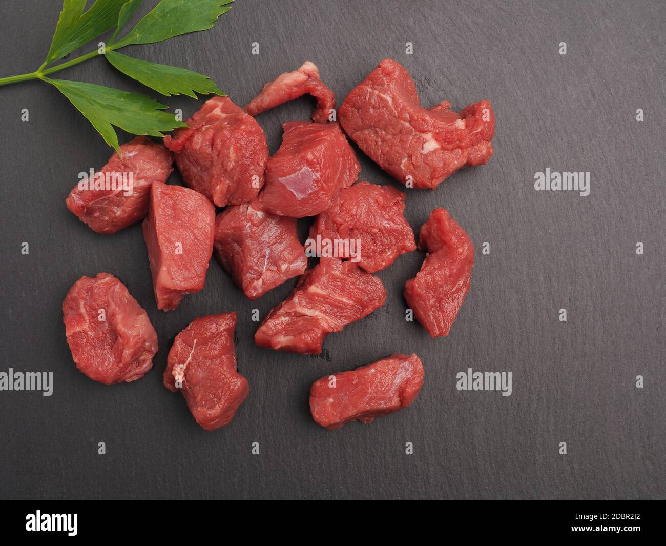 Rohes Bio-Rindfleisch auf Schieferteller mit Platz für Text, Blick von oben Stockfoto