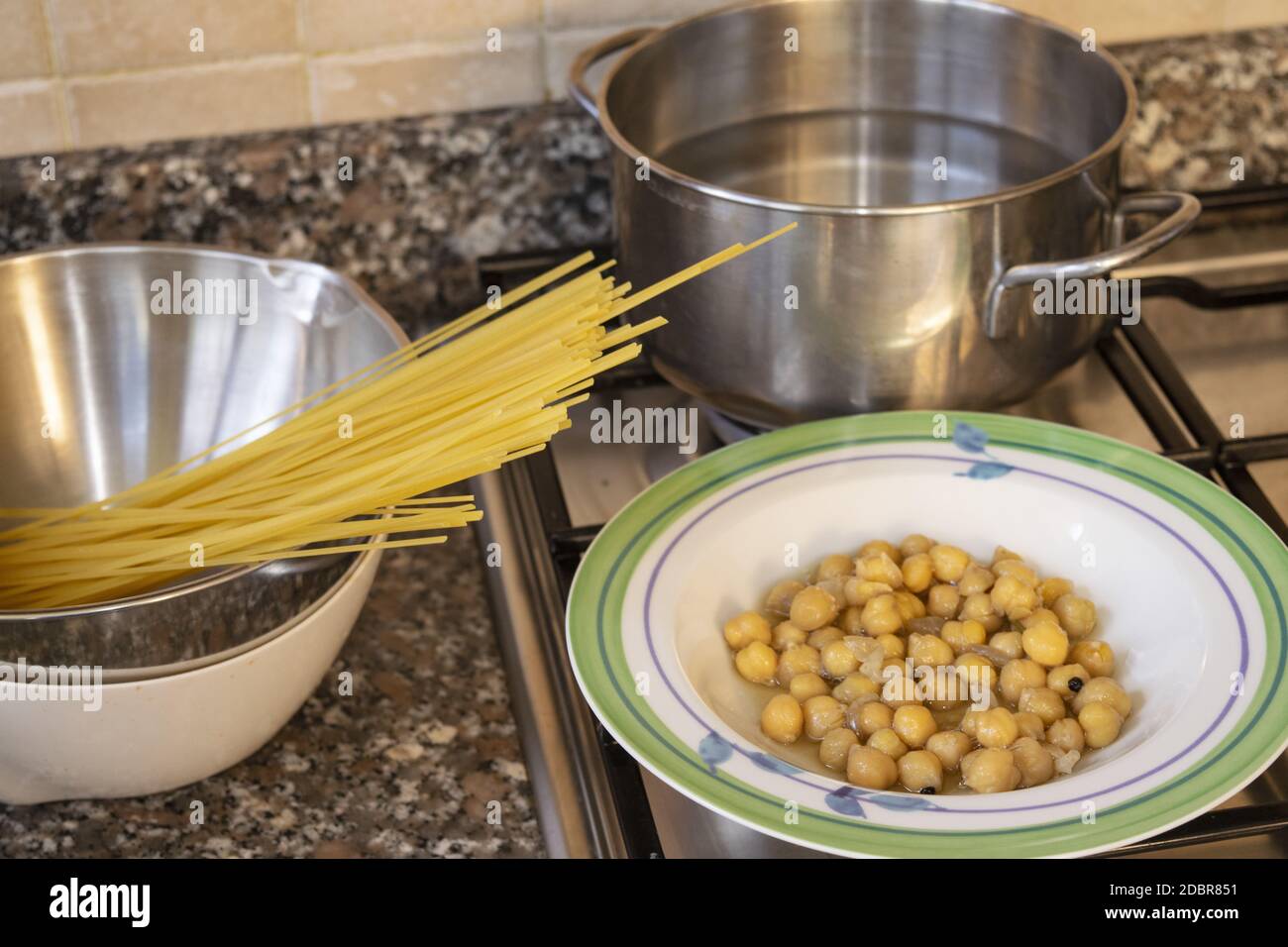 Spaghetti und Kichererbsen auf einem Kochfeld zubereiten Stockfoto