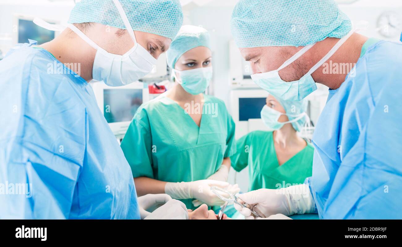 Krankenhaus - Chirurgie-team im OP-Saal oder Op einer Klinik auf einen Patienten, vielleicht ist es ein Notfall Stockfoto