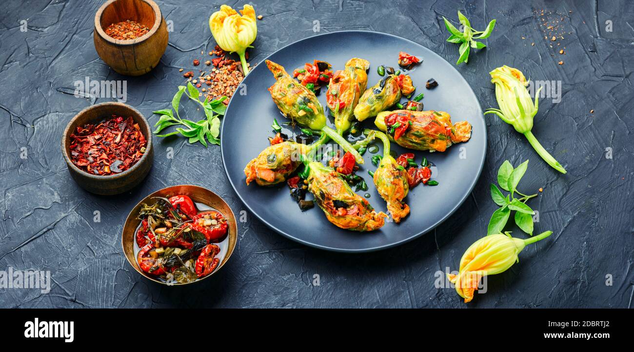 Köstliche gebratene Zucchini Blumen gefüllt mit sonnengetrockneten Tomaten.Sommer Essen. Stockfoto