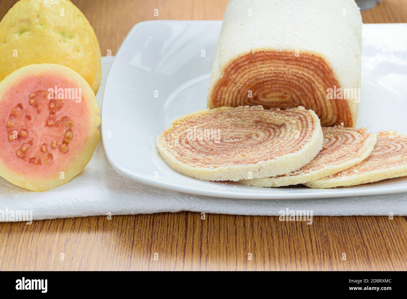 Bolo de rolo (Kuchen Rollen) neben Guavas. Traditionelle brasilianische Süßigkeit. Stockfoto