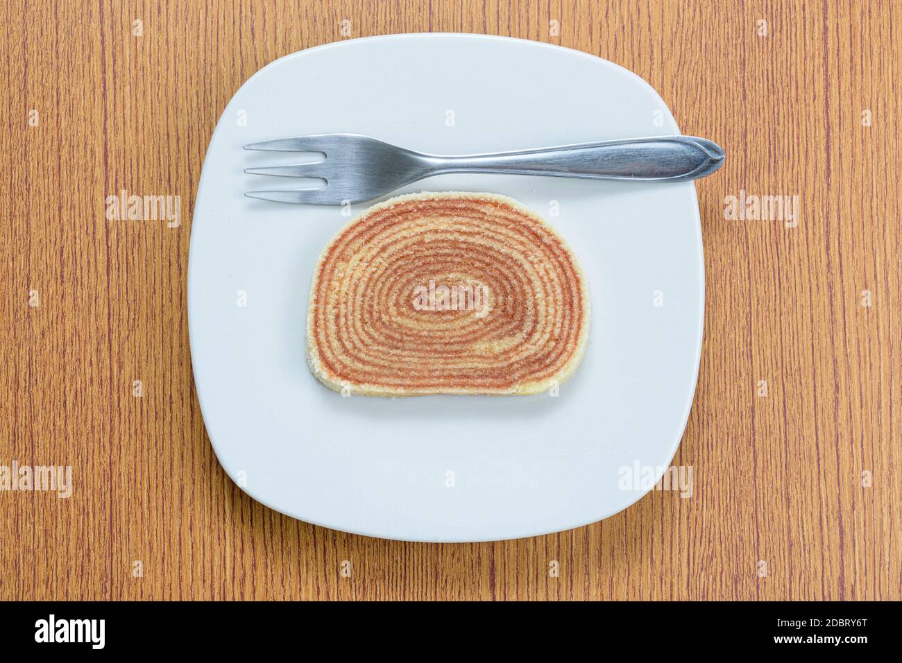 Ein Stück Kuchen (bolo de rolo) neben einer Gabel. Stockfoto