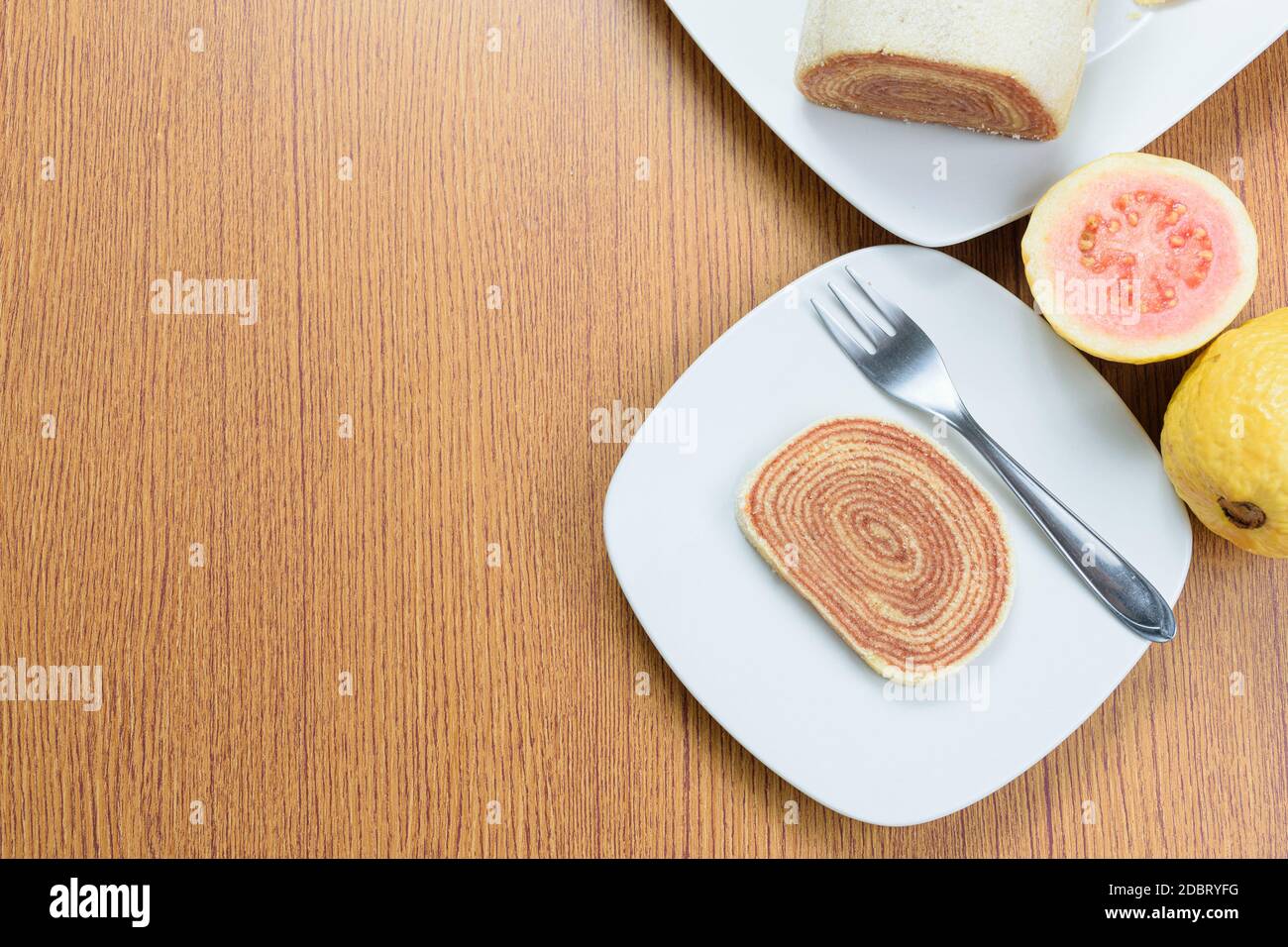 Ein Stück bolo de rolo (Kuchen Rollen) neben Guavas. Traditionelle brasilianische Candy Draufsicht. Stockfoto