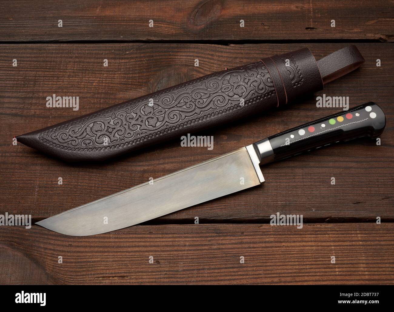 Uigur Usbekisch traditionelle universelle scharfe Messer mit einem schwarzen Griff auf einem braunen Holzhintergrund, Draufsicht Stockfoto