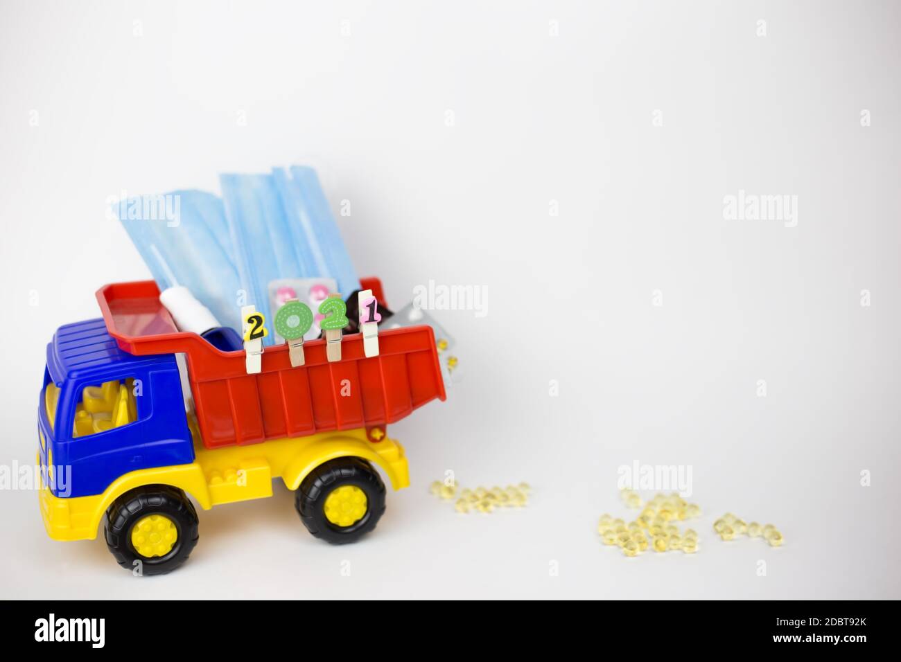 Ein Spielzeugauto trägt im neuen Jahr 2021 Masken und Medikamente. Pillen im Auto und auf dem Boden Stockfoto