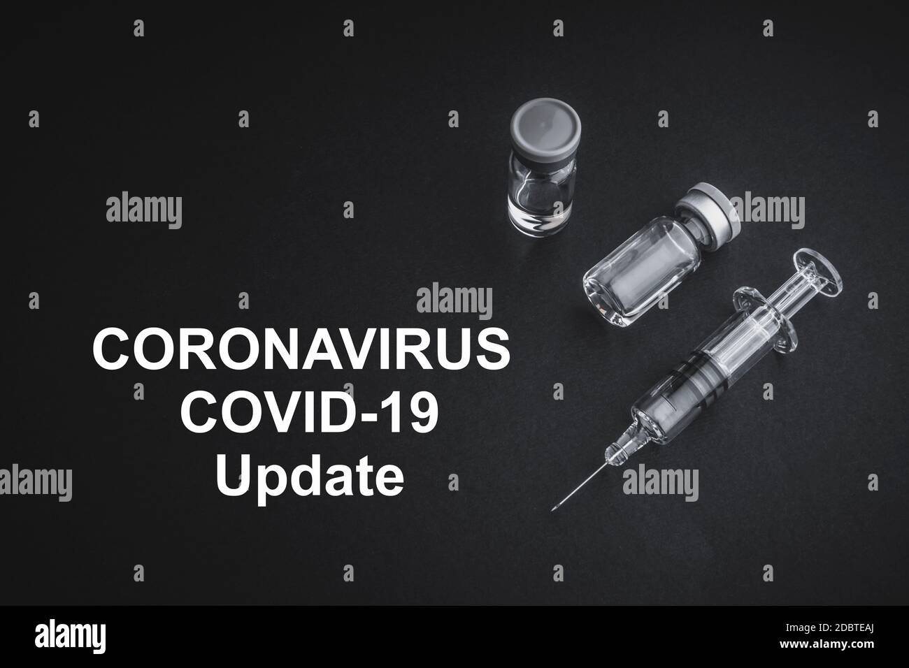 CORONAVIRUS COVID-19 UPDATE-Text mit Spritze und Fläschchen auf schwarzem Hintergrund. Covid-19 und Coronavirus-Konzept Stockfoto