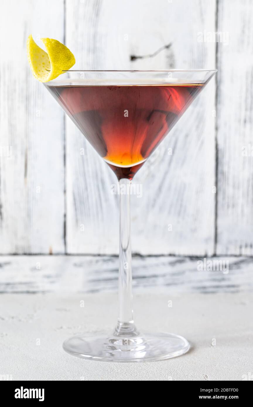 Ein Glas Martinez Cocktail garniert mit Zitronenschale Stockfoto