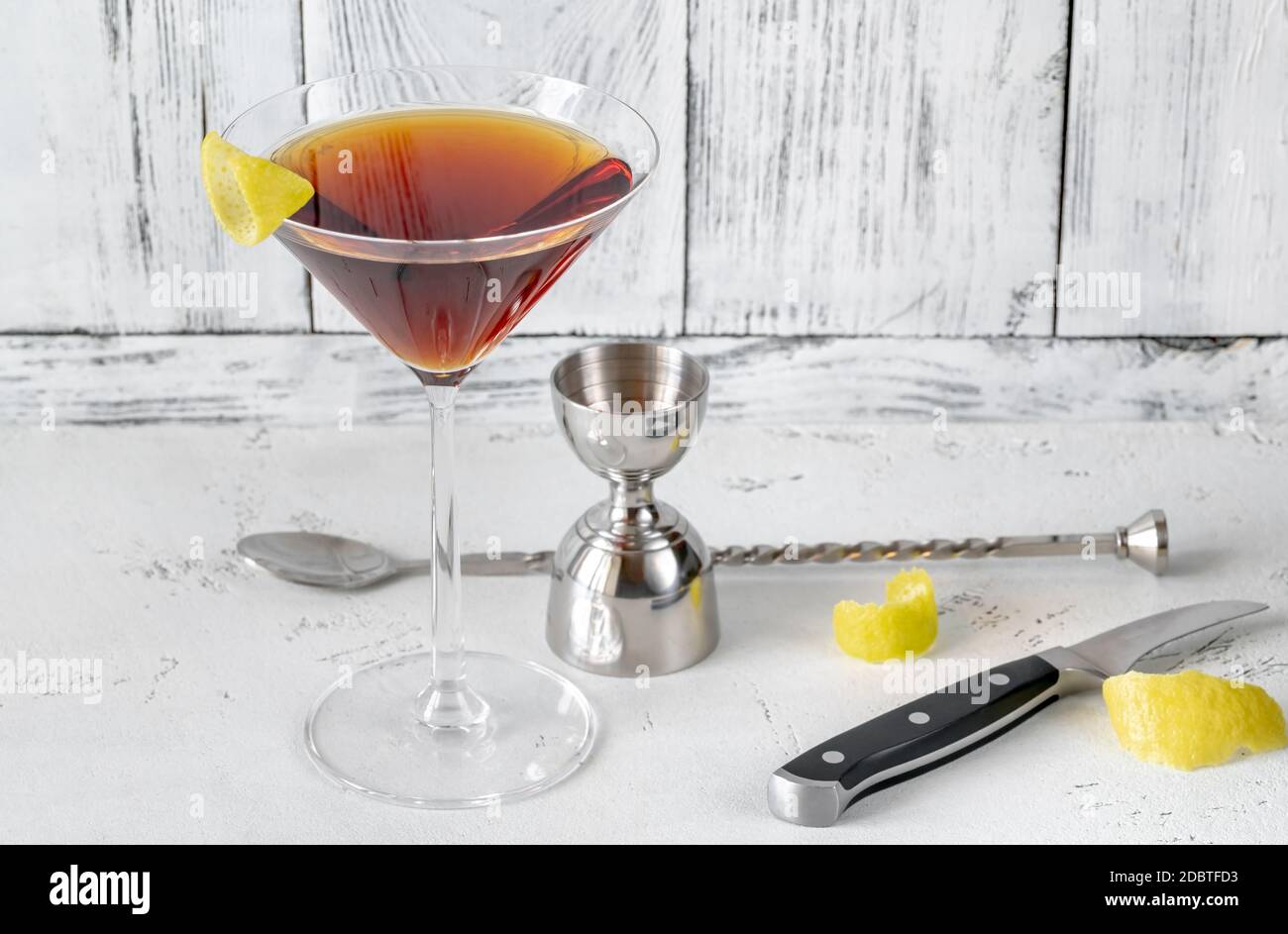 Ein Glas Martinez Cocktail garniert mit Zitronenschale Stockfoto