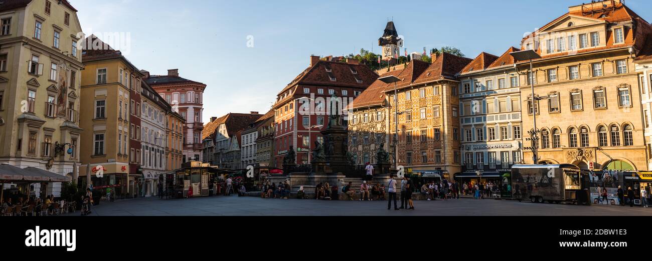 Graz, Steiermark, Österreich - 13.07.2020: Panorama von Stadtplatz, Brunnen, bemalten Fassaden und Uhrenturm in der Altstadt. Stockfoto