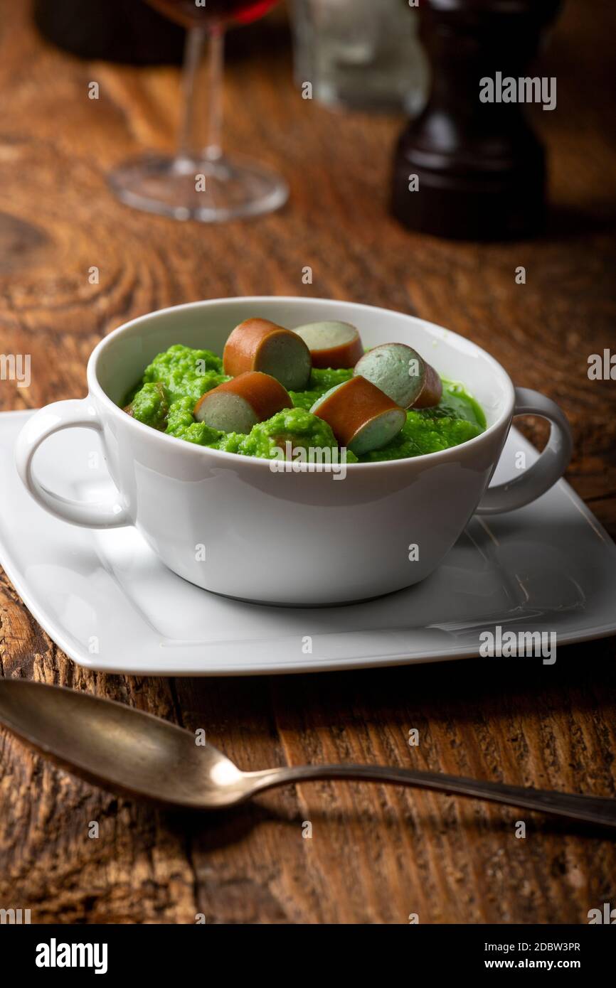 Cremige Erbsensuppe auf dunklem Holz Stockfoto