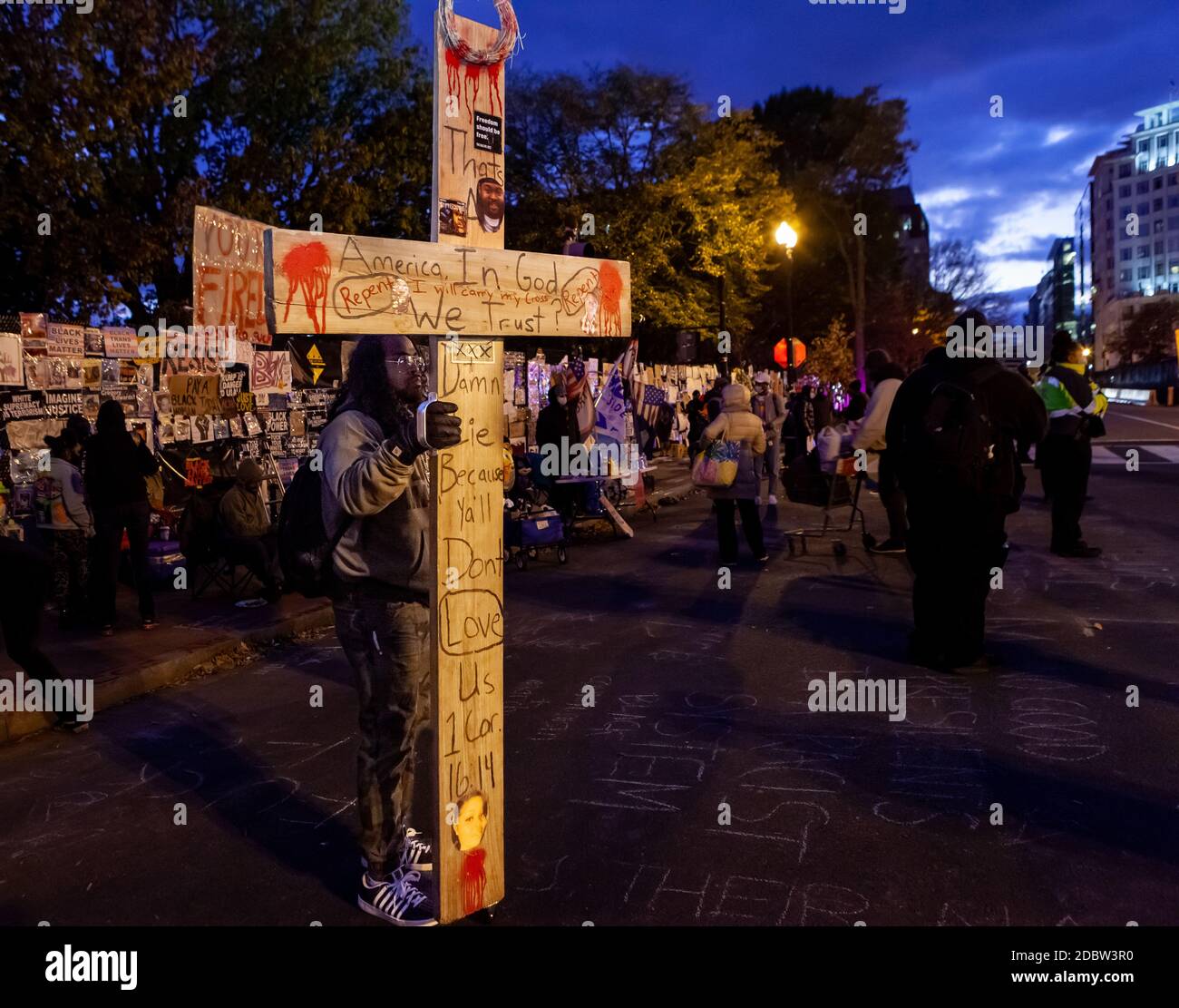 Washington, DC, USA, 17. November 2020. Im Bild: Ein Anti-Rassismus-Protestler brachte eine große nach Reclaim DC 3. Das Kreuz hinterfragte die Gottlosigkeit der USA angesichts der Tatsache, dass Schwarze Amerikaner von anderen Amerikanern nicht geliebt werden. Reklaim DC 3 war ein Kunstereignis, um das Denkmal für schwarze Opfer von Polizeigewalt und Protestkunst am Lafayette Square Zaun am Black Lives Matter Plaza wiederherzustellen. Die Veranstaltung war eine Reaktion auf die Zerstörung des Denkmals und der bestehenden Kunst durch Trump-Anhänger, weiße Vormachthaber und andere Wahlleugner am vergangenen Wochenende. Kredit: Allison C Bailey/Alamy Live Nachrichten Stockfoto