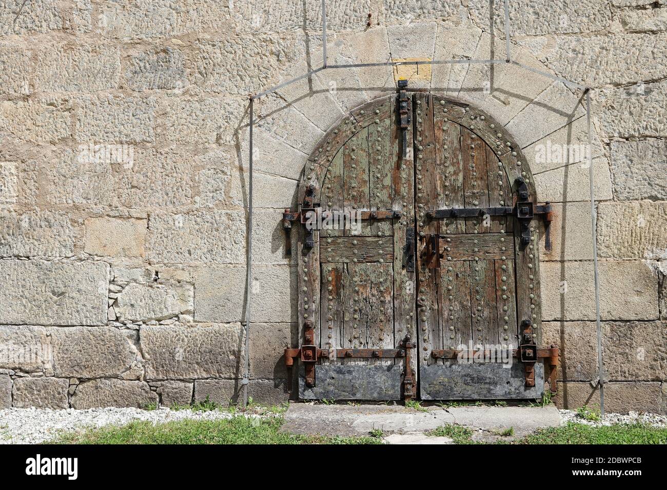 Eine alte Tür an einer Steinmauer einer Festung aus dem 18. Jahrhundert in Italien Stockfoto