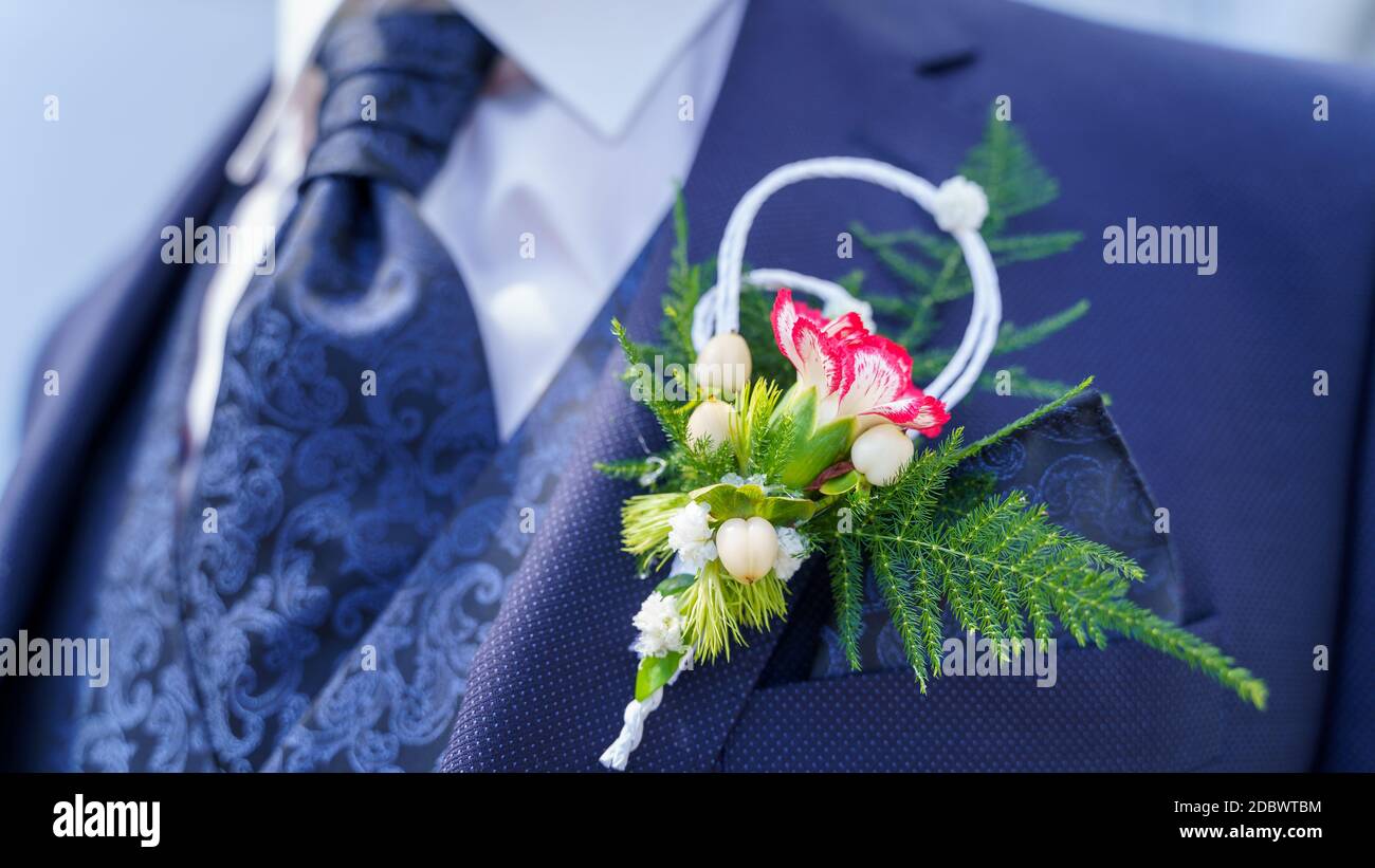 Bräutigam trägt Wedding Boutonniere auf blauem Anzug - Knopfloch Stockfoto