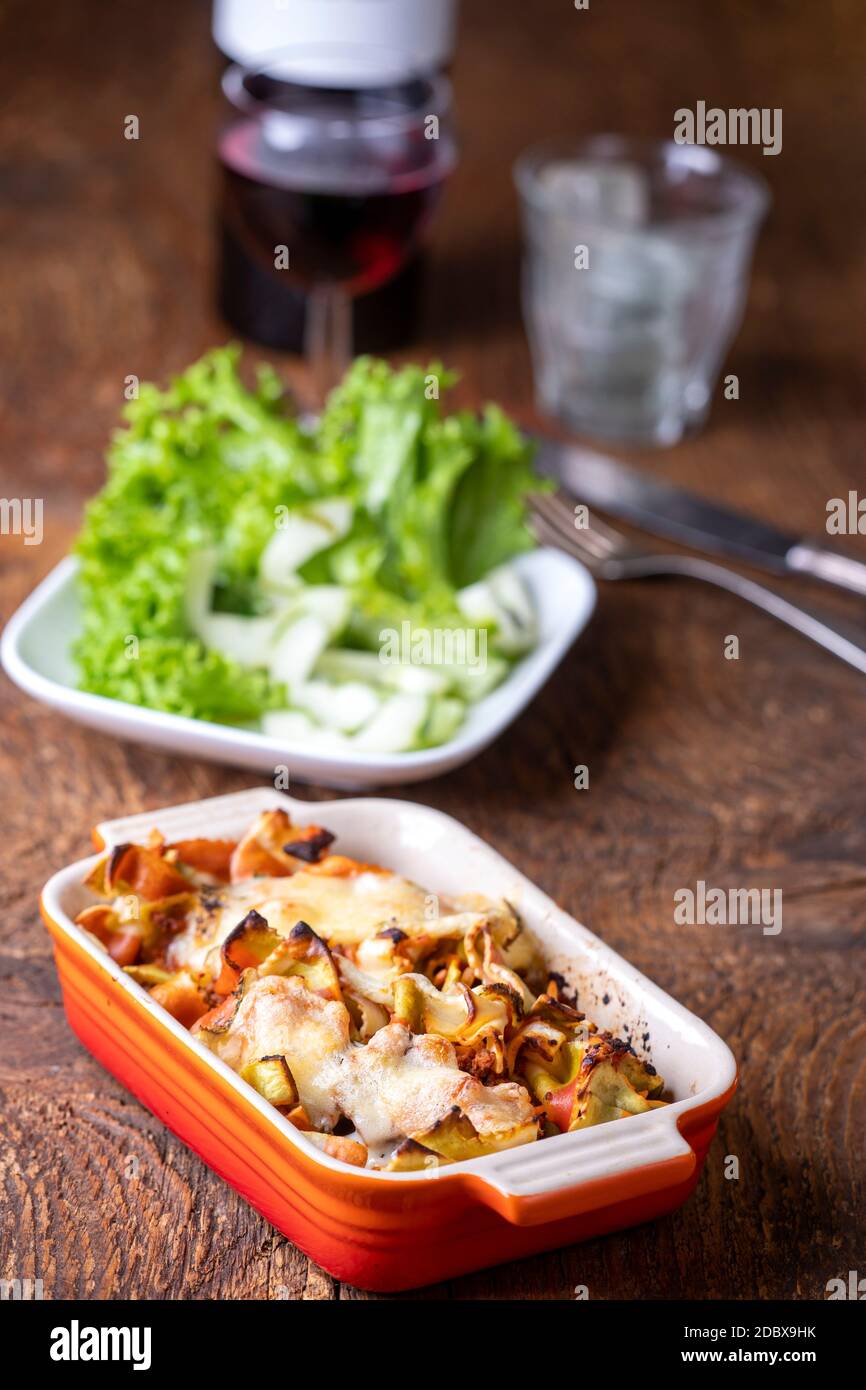 Gratinierte Pasta auf dunklem Holz Stockfoto