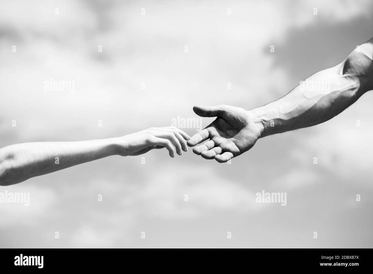Eine helfende Hand geben. Eine helfende Hand geben. Solidarität, Mitgefühl und Nächstenliebe, Rettung. Schwarz und Weiß Stockfoto