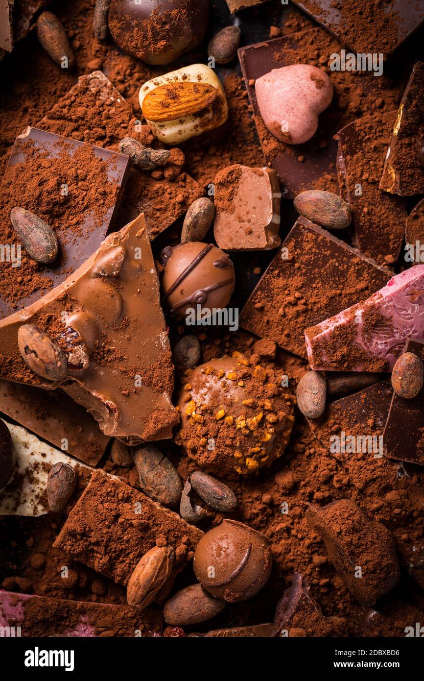 Variation von Schokolade und Schokolade Süßigkeiten mit Kakao und Kakao Bohnen als Hintergrund Stockfoto