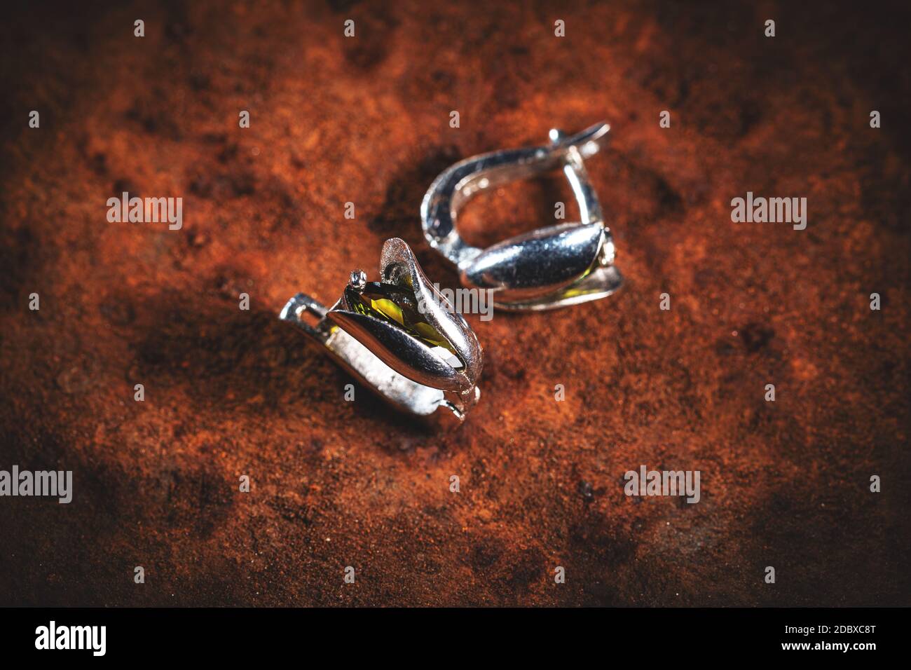 Moderne minimalistische silberne Ohrringe auf braunem Hintergrund Stockfoto