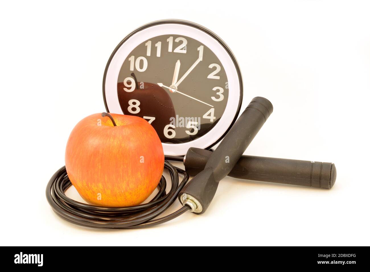 Ein isoliertes Springseil mit Apfel und Uhr für eine Vielzahl von Übungskonzepten. Stockfoto