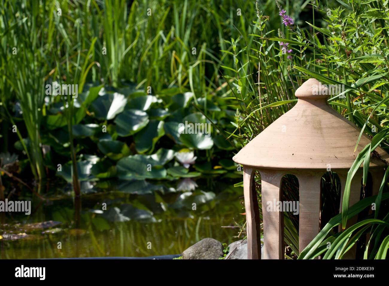 Gartenteich im Sommer mit Dekoration Stockfoto