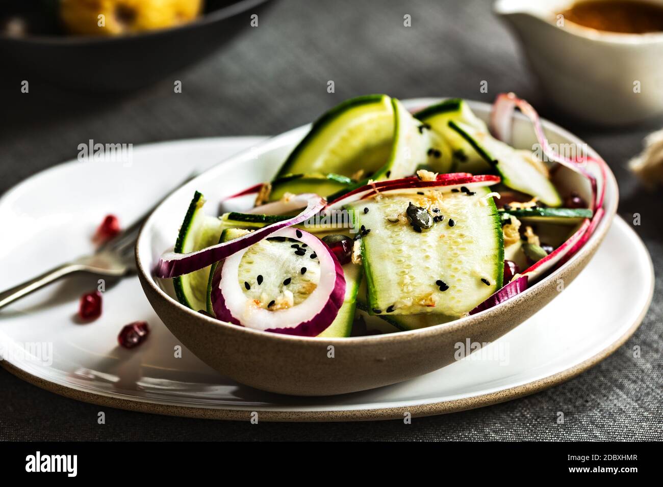 Zucchini, rote Zwiebel und Granatapfel mit Sesamsoja und Ingwer-Dressing Stockfoto