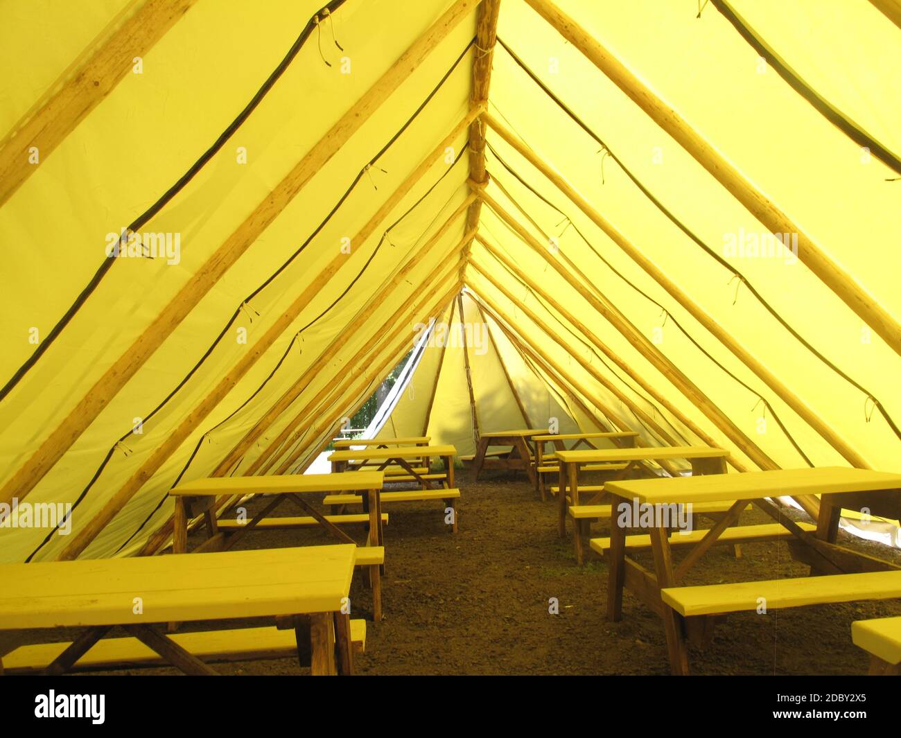 Gelbes Zelt mit Picknicktischen und Bänken Stockfoto