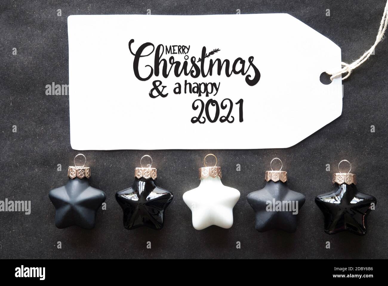 Label mit englischer Kalligraphie Frohe Weihnachten und EIN glückliches 2021. Schwarze Weihnachtskugel Ornament. Stockfoto