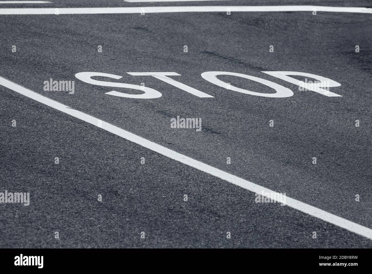 Stop Wort über eine asphaltierte Straße Stockfoto
