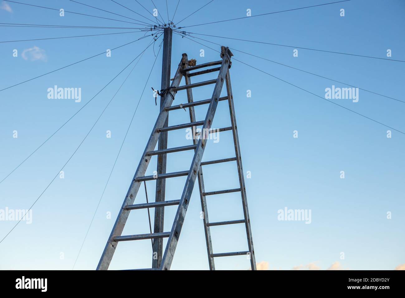 Elektrische Verkabelung auf dem Dach eines Hochhauses, eine Doppeltreppe gegen den blauen Himmel. Speicherplatz kopieren Stockfoto