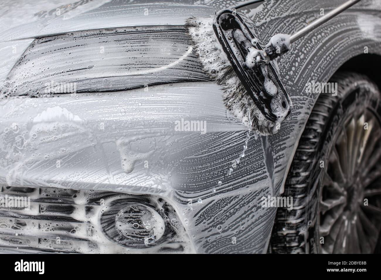 Detailansicht der vorderen in Seife Schaum bedeckt, gewaschen mit Pinsel in der Waschstraße. Stockfoto