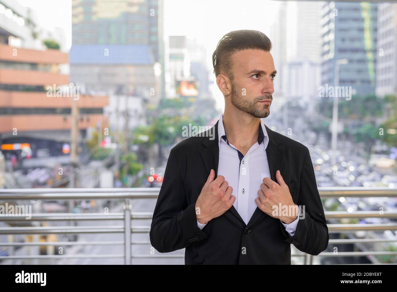 Porträt eines hübschen jungen Geschäftsmannes, der im Freien in der Stadt denkt Stockfoto