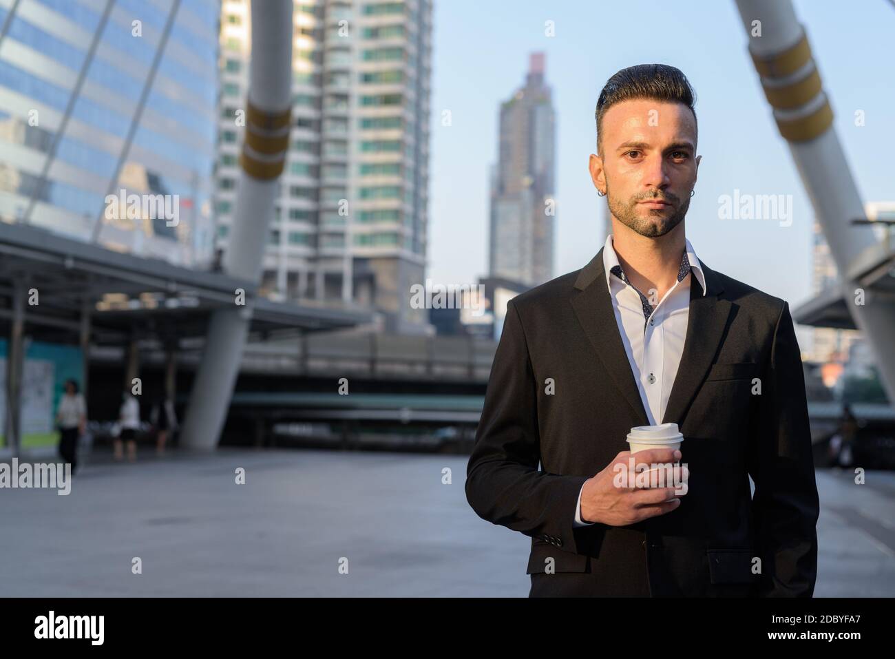Porträt eines gutaussehenden jungen Geschäftsmann im Freien in der Stadt hält Kaffee becher Stockfoto